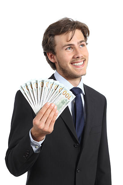 Happy businessman holding money and looking sideways isolated on a white background